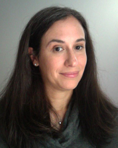 A head and shoulders photo of a woman with a grey background