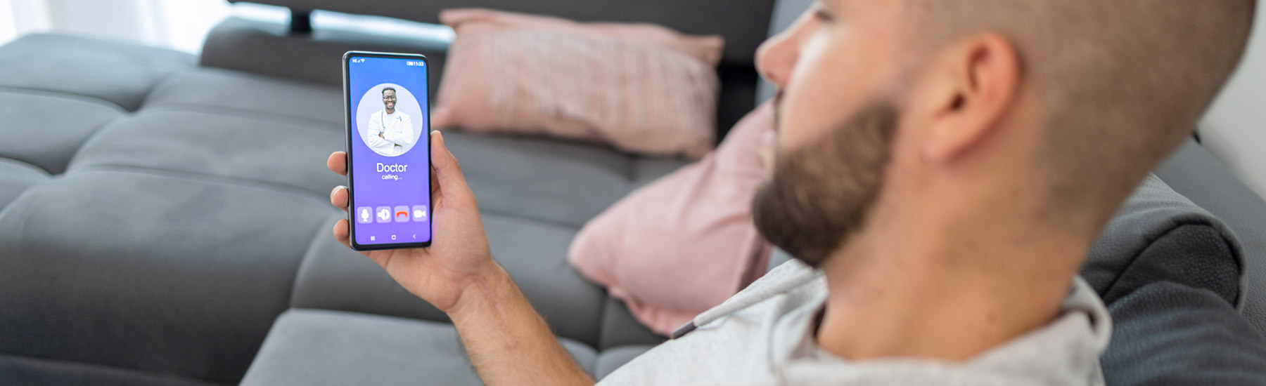 telehealth A man in a gray jacket making a phone call