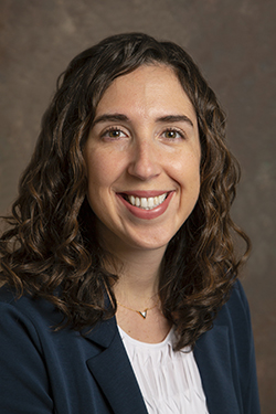 A brown haired woman with a grey photo background